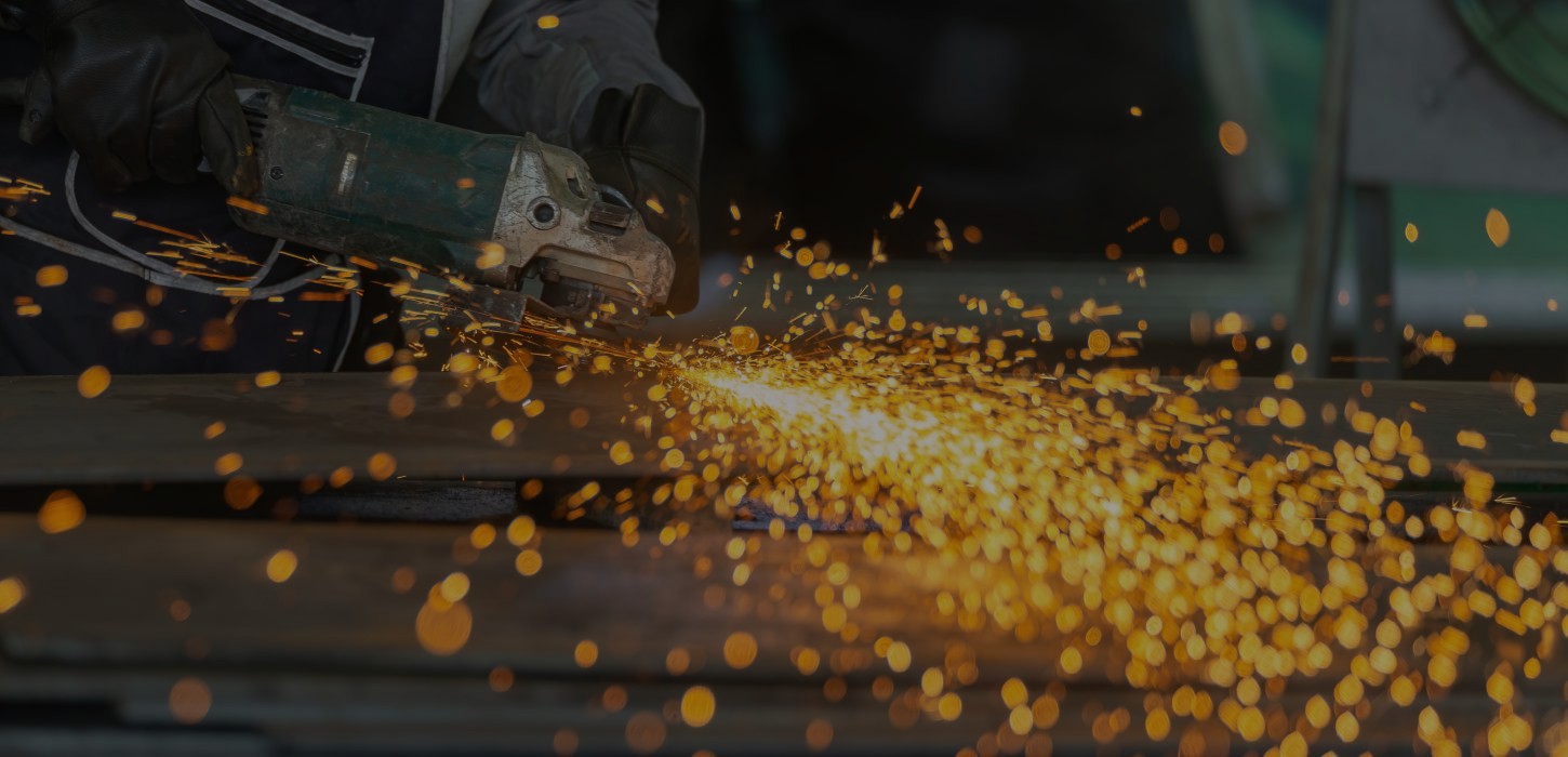 An close-up of a power tool making contact with metal and throwing sparks