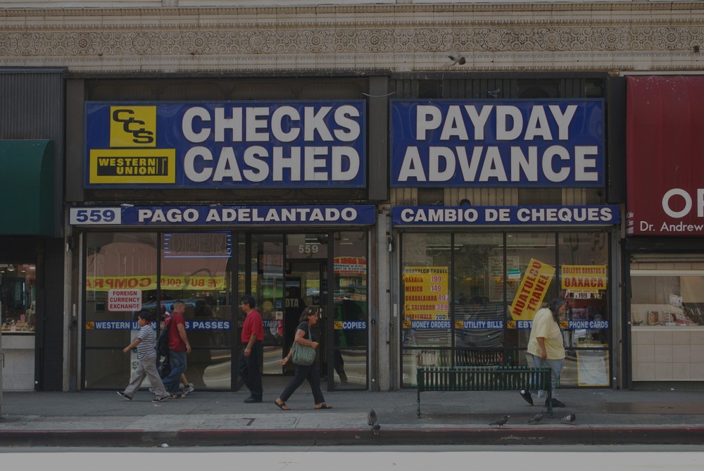 Pedestrians walk past a payday loan storefront.